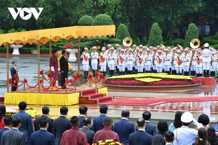 Chủ tịch nước Lương Cường và Quốc vương Bhutan Jigme Khesar Namgyel Wangchuck đứng trên bục danh dự, nghe Quân nhạc cử Quốc thiều hai nước.