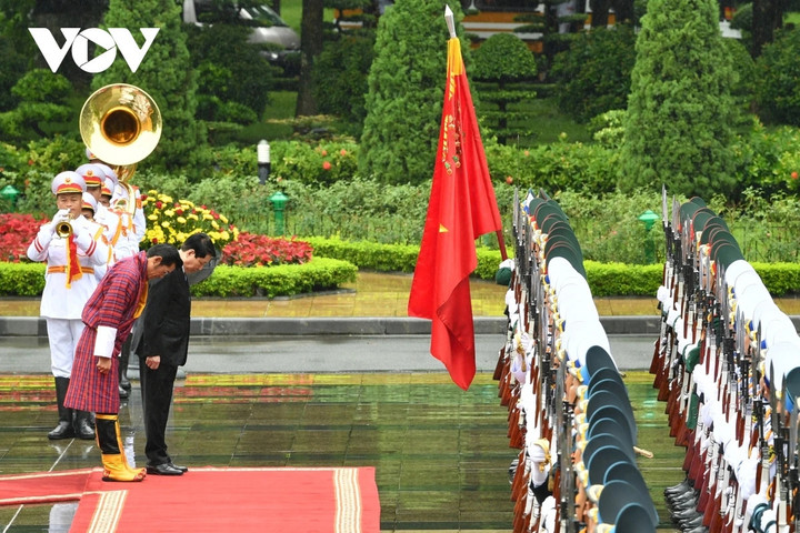 Chủ tịch nước Lương Cường và Quốc vương Bhutan Jigme Khesar Namgyel Wangchuck cúi chào Quân kỳ Quyết thắng của Quân đội nhân dân Việt Nam.
