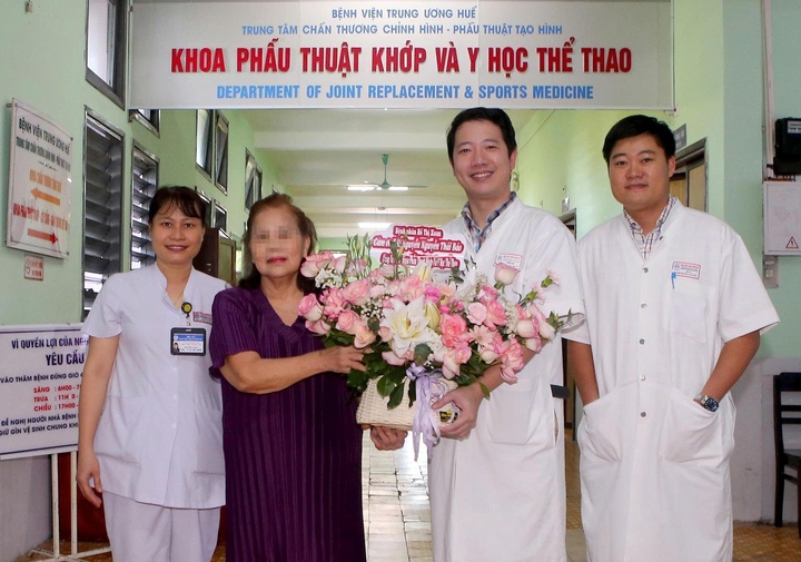 Lãnh đạo Khoa Phẫu thuật Khớp – Y học thể thao Bệnh viện Trung ương Huế tặng hoa chúc mừng bệnh nhân Hồ Thị X. trong ngày được xuất viện. (Ảnh: BVCC)