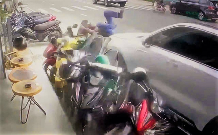 Hình ảnh chiếc ô tô tông một người đi đường và lao vào hàng loạt xe máy đậu trên vỉa hè