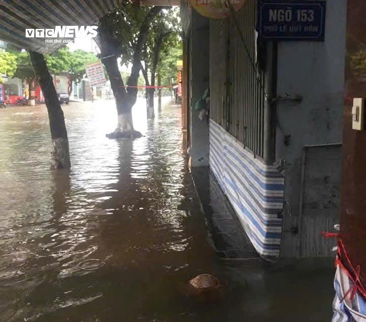 Nhiều gia đình dùng bạt căng trước cửa để hạn chế việc ô tô đi qua khiến nước tràn vào nhà.