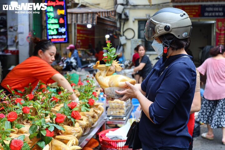 Người dân chọn mua gà cúng đã bày sẵn tại chợ. (Ảnh: Minh Đức)