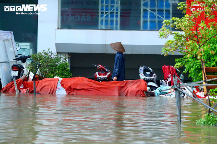 Nhiều nhà dân, cửa hàng phải chặn hầm để xe bằng bao cát, bạt để nước không tràn vào.