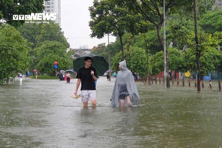 Đến đầu giờ chiều, hồ Văn Quán ngập mênh mông, trong khi trời vẫn trút mưa không ngớt.