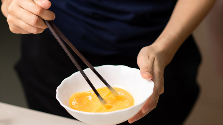 Đánh đều tay - một bí quyết rán trứng mềm xốp, thơm ngon. (Ảnh: Shutterstock)