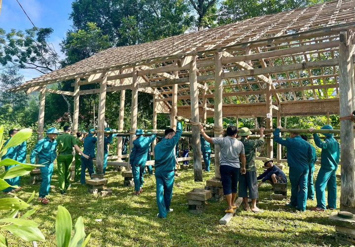 Lực lượng chức năng hỗ trợ gia đình dựng nhà tạm ở vị trí an toàn.