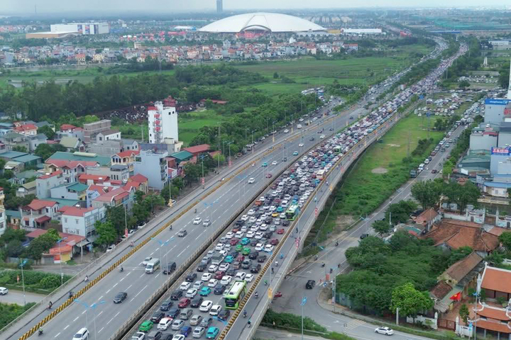 Hàng dài phương tiện nối đuôi nhau hướng về Trung tâm Hội chợ Triển lãm Quốc gia.