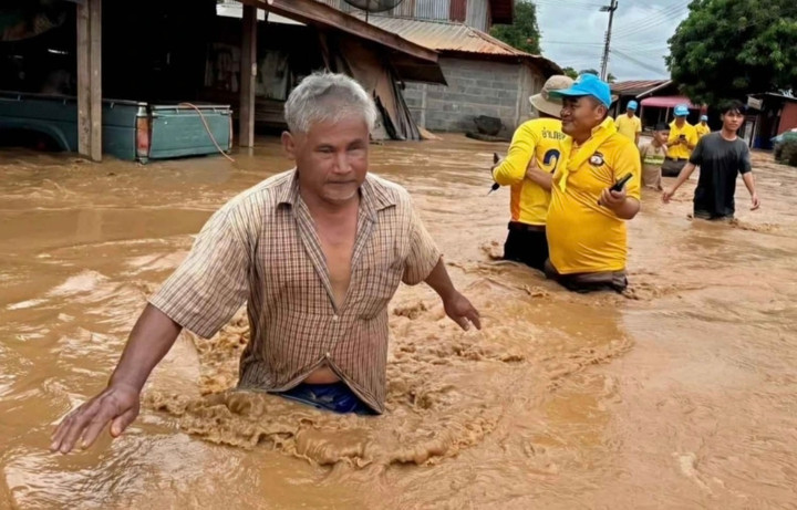 Người dân lội qua dòng nước lũ ngập đến thắt lưng tại huyện Lom Kao, tỉnh Phetchabun, Thái Lan vào hôm Chủ nhật (31/8/2025). (Ảnh: Soonthorn Kongwarakom/Bangkok Post)