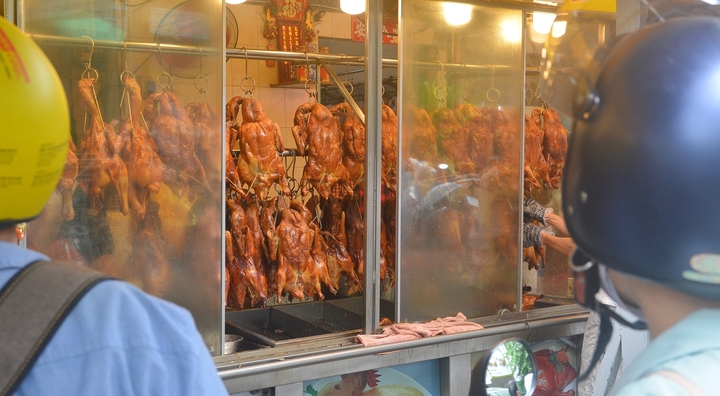 Người dân chờ lấy vịt quay nóng hổi tại các cửa tiệm. (Ảnh: Đại Việt)