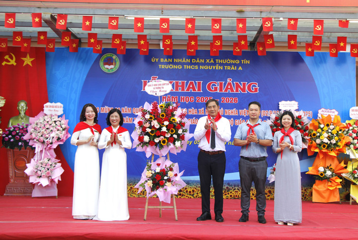 Ông Nguyễn Xuân Minh, Bí thư Đảng ủy xã Thường Tín (thứ 3 từ phải sang), tặng hoa chúc mừng trường THCS Nguyễn Trãi A.