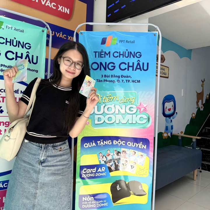Khách hàng hào hứng nhận quà được thiết kế riêng bởi Dương Domic ngay tại trung tâm tiêm chủng Long Châu.