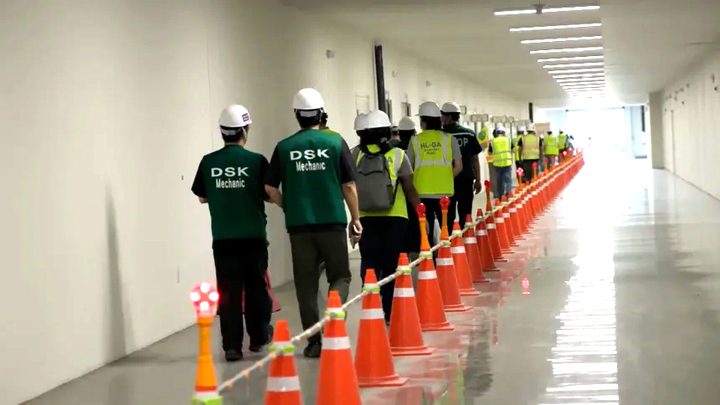 Các công nhân đứng xếp thành hàng trước khi làm thủ tục. (Ảnh: CNN)