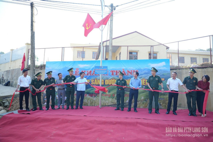 Các đại biểu kéo băng gắn biển khánh thành công trình "Thắp sáng đường thôn biên giới".