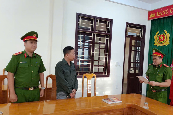 Cán bộ Cơ quan CSĐT Công an tỉnh Quảng Trị đang tuyên đọc quyết định khởi tố đối với Nguyễn Viết Hải. (Ảnh: Công an Quảng Trị)