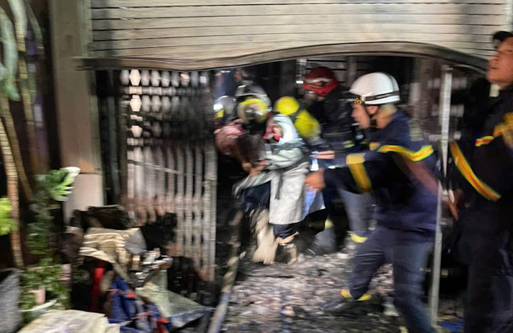 Cảnh sát phá cửa cuốn cứu nạn nhân mắc kẹt bên trong đám cháy.