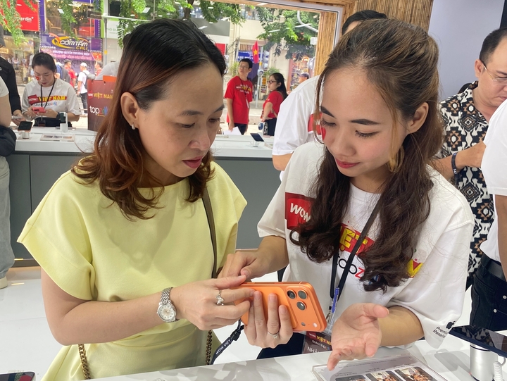 Frau Tram aus dem Bezirk Tan Hung in Ho-Chi-Minh-Stadt ist eine der ersten Kundinnen, die das kosmisch orange iPhone 17 Pro Max im TopZone-System auspackt. (Foto: Dai Viet)
