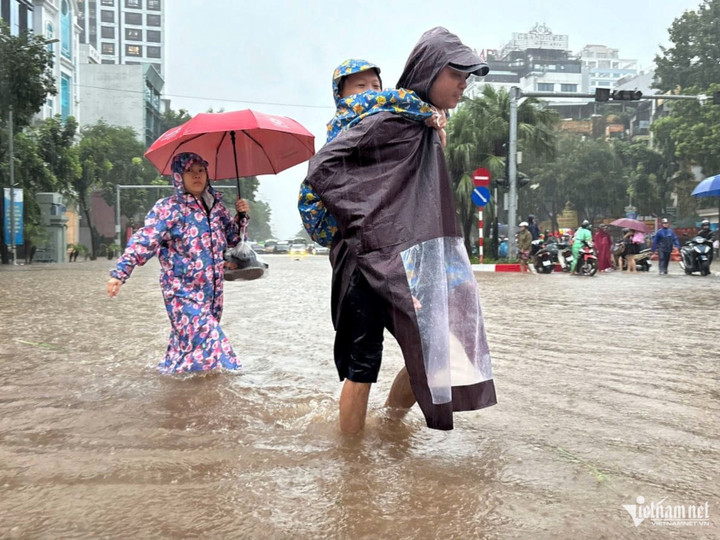 Ngập nặng tại Liễu Giai, Văn Cao, phụ huynh phải lội nước cõng con từ trường về. Ảnh: Thạch Thảo
