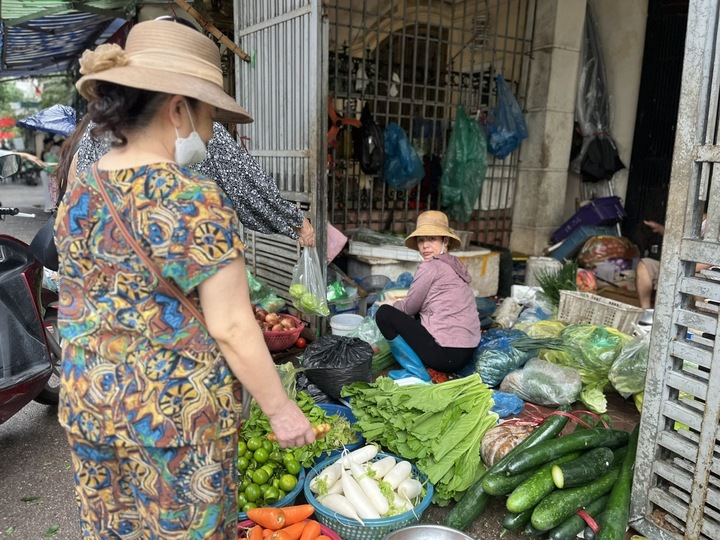 Người dân đi chợ mua rau xanh từ sáng sớm. (Ảnh: Hoàng Dung).