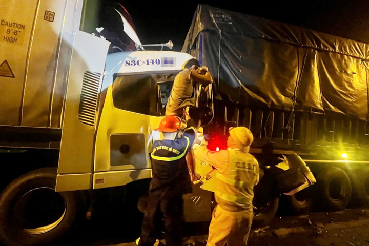 Lực lượng chức năng đưa 2 người mắc kẹt ra ngoài và đi cấp cứu. (Ảnh: A.X)