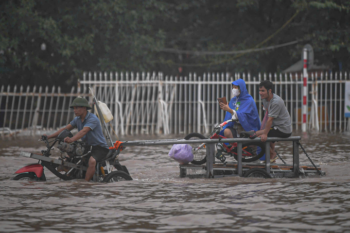 Mưa lớn biến Mỹ Đình thành biển nước, dân trả trăm nghìn thuê kéo xe qua điểm ngập