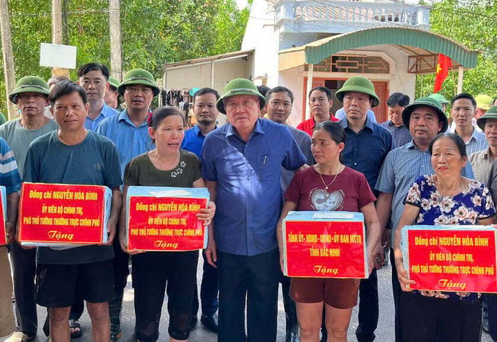 Phó Thủ tướng Thường trực Nguyễn Hoà Bình tặng quà cho người dân vùng lũ lụt xã Yên Thế. (Ảnh: VGP).