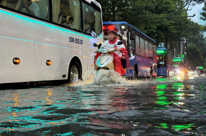 Nhiều xe khách, xe buýt nối đuôi nhau vì di chuyển chậm qua vùng ngập.