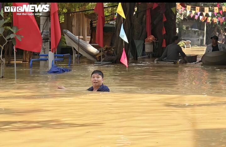Con đường mọi khi nay biến thành "dòng sông" ngập gần tới cổ ông Lợi.