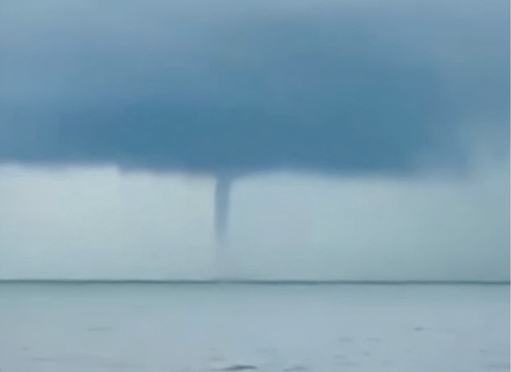 Vòi rồng cao hàng trăm mét xuất hiện gần bờ biển thuộc xã Hải Tiến. (Ảnh: Cắt từ clip)