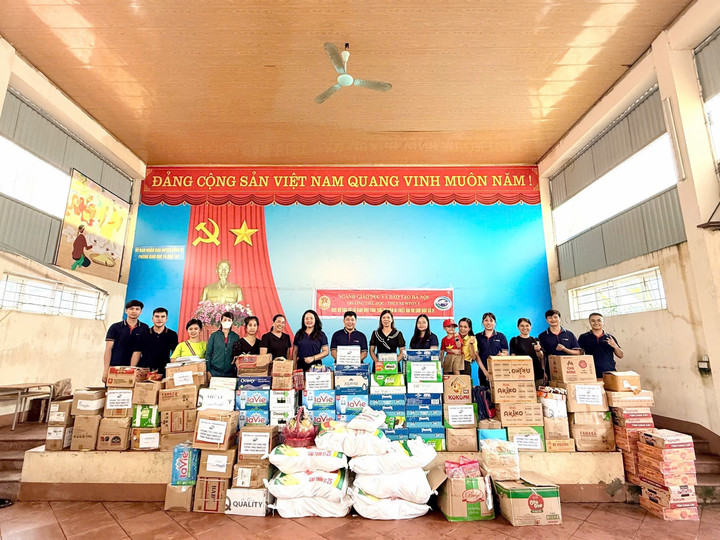 Cô Lê Thị Thanh Nhàn và phụ huynh trao quà cho học sinh Tiểu học Sông Cầu, chụp ảnh cùng cô Nguyễn Thị Thu Huyền, cô Triệu Thị Định và giáo viên hai trường.