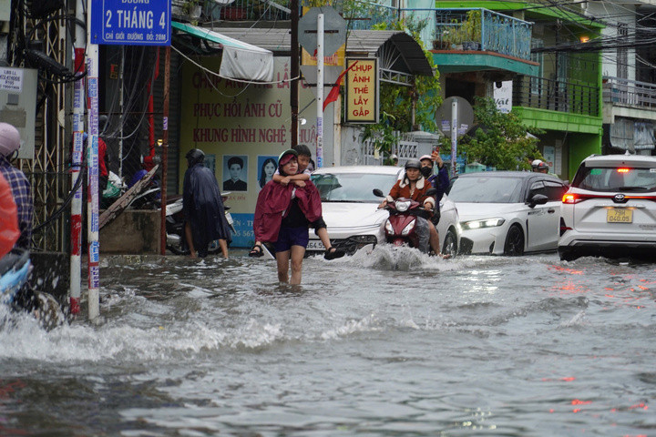 Nhiều phụ huynh phải lội nước, cõng con đến trường.