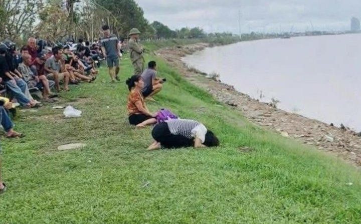 Người thân ngồi bên bờ sông chờ tin tức ba bố con.