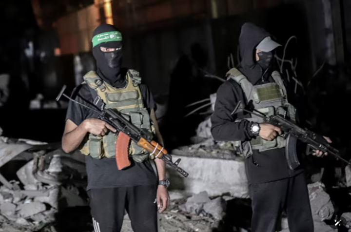 Các tay súng Palestine mặc quân phục của Lữ đoàn al-Qassam - cánh quân sự của Hamas - giám sát các xe của Ủy ban Chữ thập đỏ Quốc tế khi họ nhận hài cốt con tin Israel được Hamas bàn giao tại Thành phố Gaza, ngày 15/10/2025. Ảnh : Getty Images
