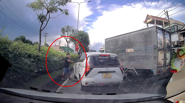 Clip lan truyền trên mạng ghi lại cảnh tài xế xe tải chặn đầu, cầm hung khí đập vỡ kính ô tô trên đường Lê Quang Đạo (xã Hóc Môn), khiến nhiều phương tiện ùn ứ. (Ảnh: Cắt từ clip)