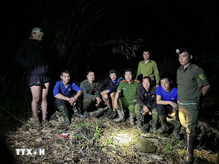 Lực lượng tìm kiếm tiếp cận, sơ cứu cho du khách bị thương khi đi lạc trong rừng đặc dụng. (Ảnh: TTXVN)