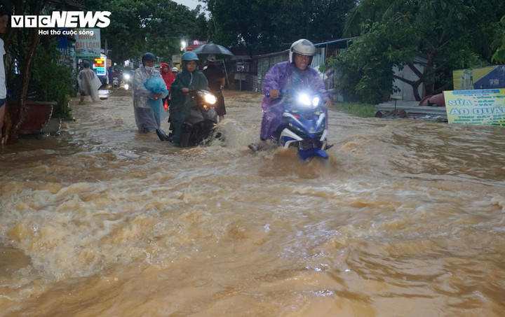 Dòng nước lũ đục ngầu từ khu vực núi đổ xuống, chảy xiết qua các khu dân cư trên đường Âu Cơ, phường Liên Chiểu (TP Đà Nẵng).