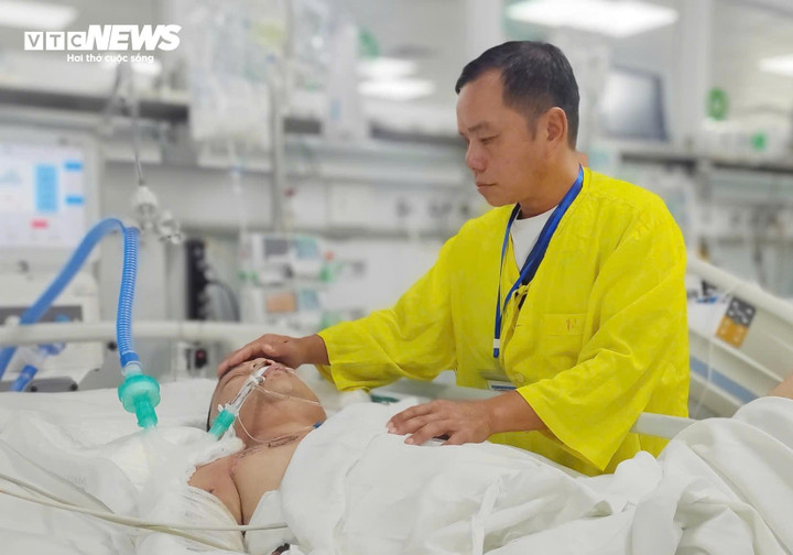 Ông Tình chăm sóc con trai bên giường bệnh. (Ảnh: Loan Hoà)