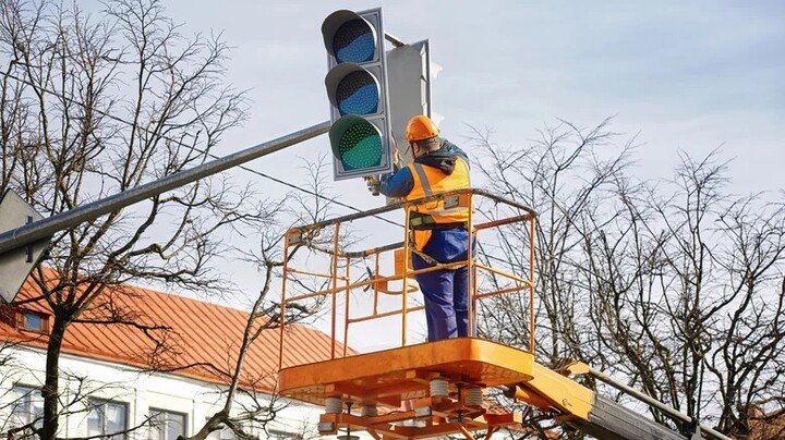 Workers maintain traffic lights – an illustration of infrastructure improvements to prepare for the possibility of integrating white lights specifically for self-driving cars in the future. (Source: Shutterstock)