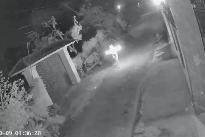 Hình ảnh người đàn ông cầm theo “bom xăng” đang cháy, chạy đến trước cổng nhà dân (Ảnh: Cắt từ clip).