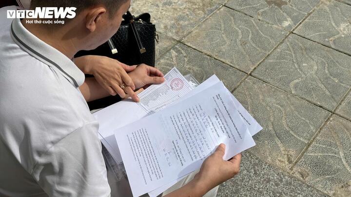 Người dân kiểm tra lại giấy tờ chờ đến lượt lấy số, nộp hồ sơ.