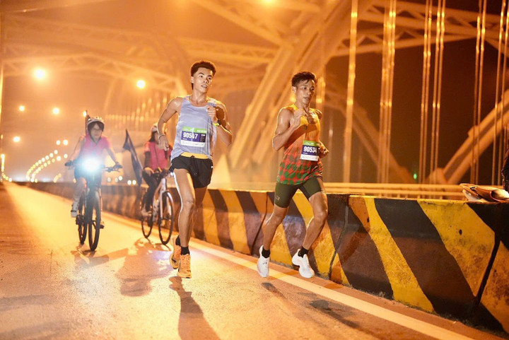 Huỳnh Anh Khôi (trái) và Nguyễn Văn Lai so kè trên đường chạy VPBank Hanoi International Marathon 2025.