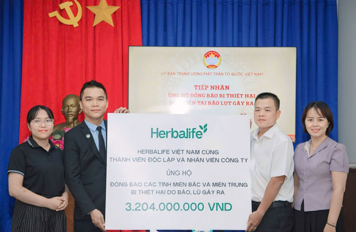 Ông Nguyễn Thành Đạt, Giám Đốc Truyền Thông Herbalife Việt Nam, trao tiền ủng hộ cho đại diện Mặt trận Tổ quốc Việt Nam.