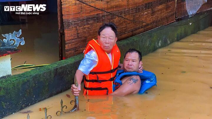 Nước ngập quá sâu, người dân TP Huế bì bõm trong nước chờ cứu hộ.
