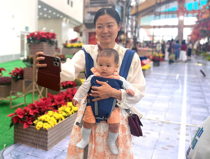 Một em bé được mẹ đưa đi hội chợ. (Ảnh: Hoàng Dung).