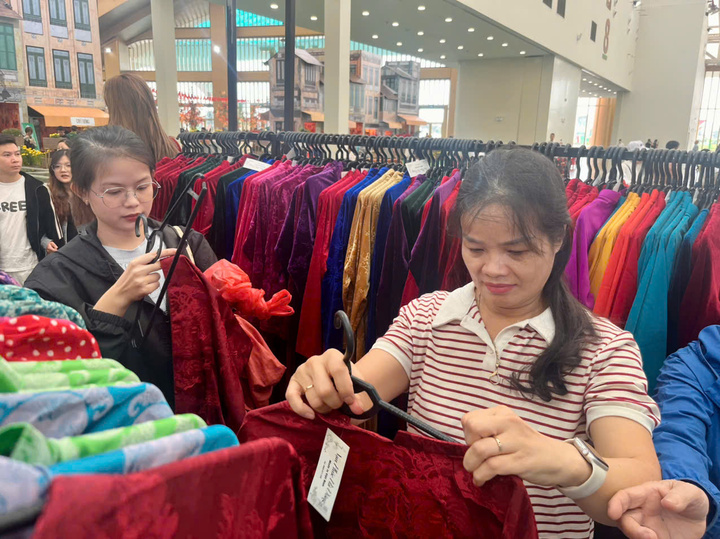 Thảo cùng mẹ thử áo dài được bày bán ở hội chợ. (Ảnh: Hoàng Dung).