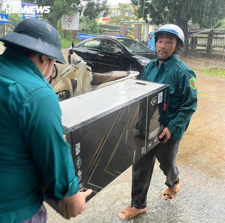 Lực lượng chức năng hỗ trợ người dân di dời tài sản, sơ tán đến nơi an toàn khi lũ dâng.