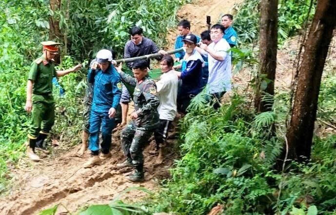 Nhiều người phối hợp khiêng thai phụ D. vượt qua các điểm sạt lở.