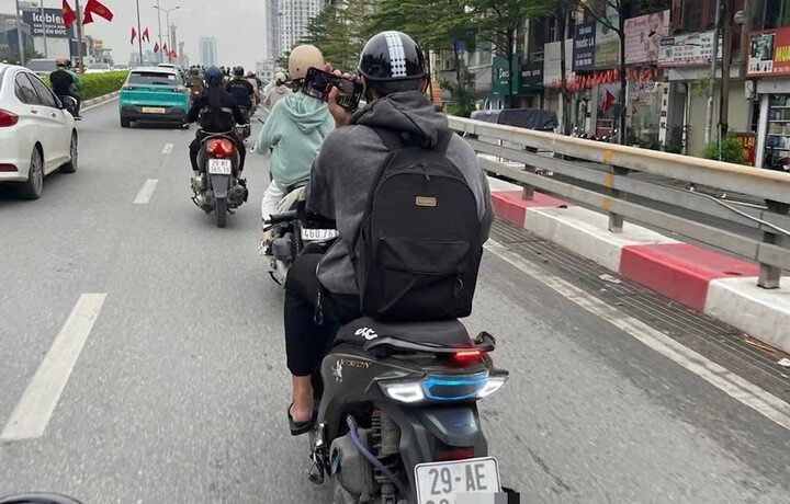 Hình ảnh nam thanh niên vừa lái xe máy vừa sử dụng điện thoại bị người đi đường phản ánh.