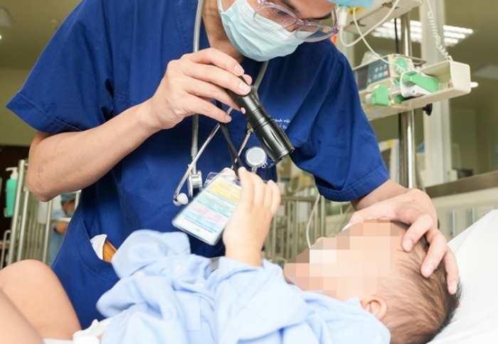 Bé trai 14 tháng tuổi phải nhập viện vì nuốt hạt nở đồ chơi ThS.BS Nguyễn Đức Thường thăm khám cho trẻ.