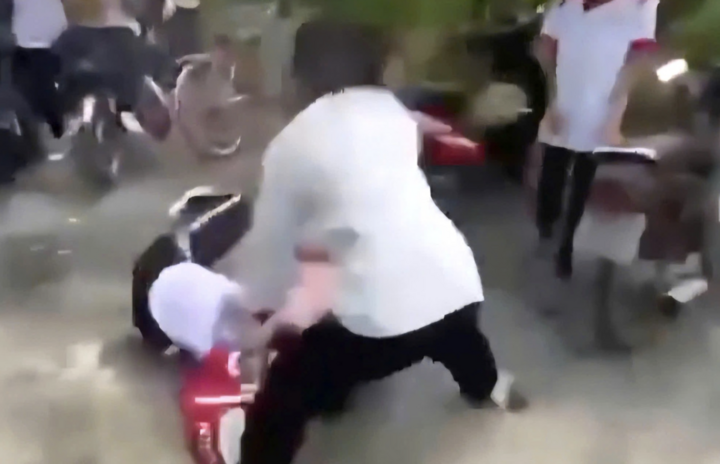 Bild på en grupp elever som använder hjälmar för att slå elev A. (Foto utklippt från klipp)