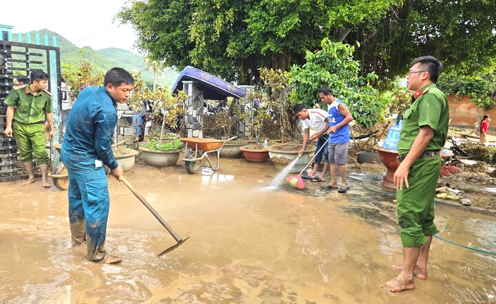 Lực lượng chức năng xã Tuy Phong giúp người dân dọn dẹp nhà cửa.